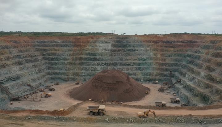 Cobre Panama: First Quantum возобновит работы на закрытом руднике Огромный открытый медный карьер с отвалами руды и простаивающей карьерной техникой под пасмурным небом в Панаме.